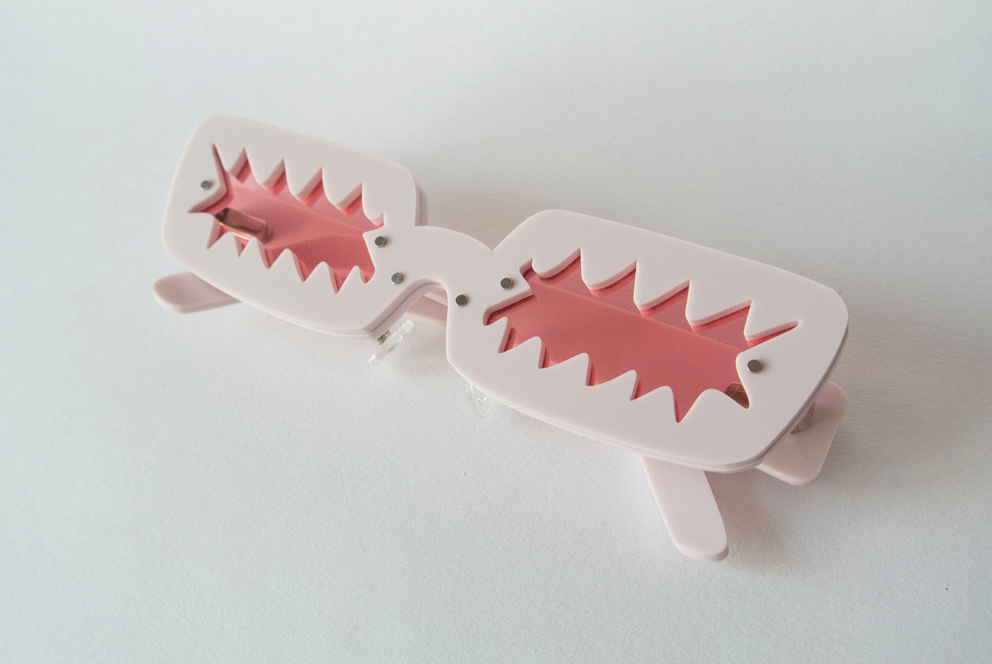 light pink coloured glasses with pink zigzag shaped lenses