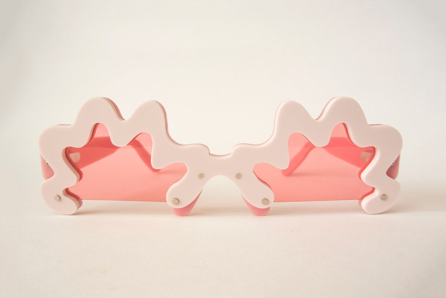 pink sunglasses with wriggly edges and pink lenses