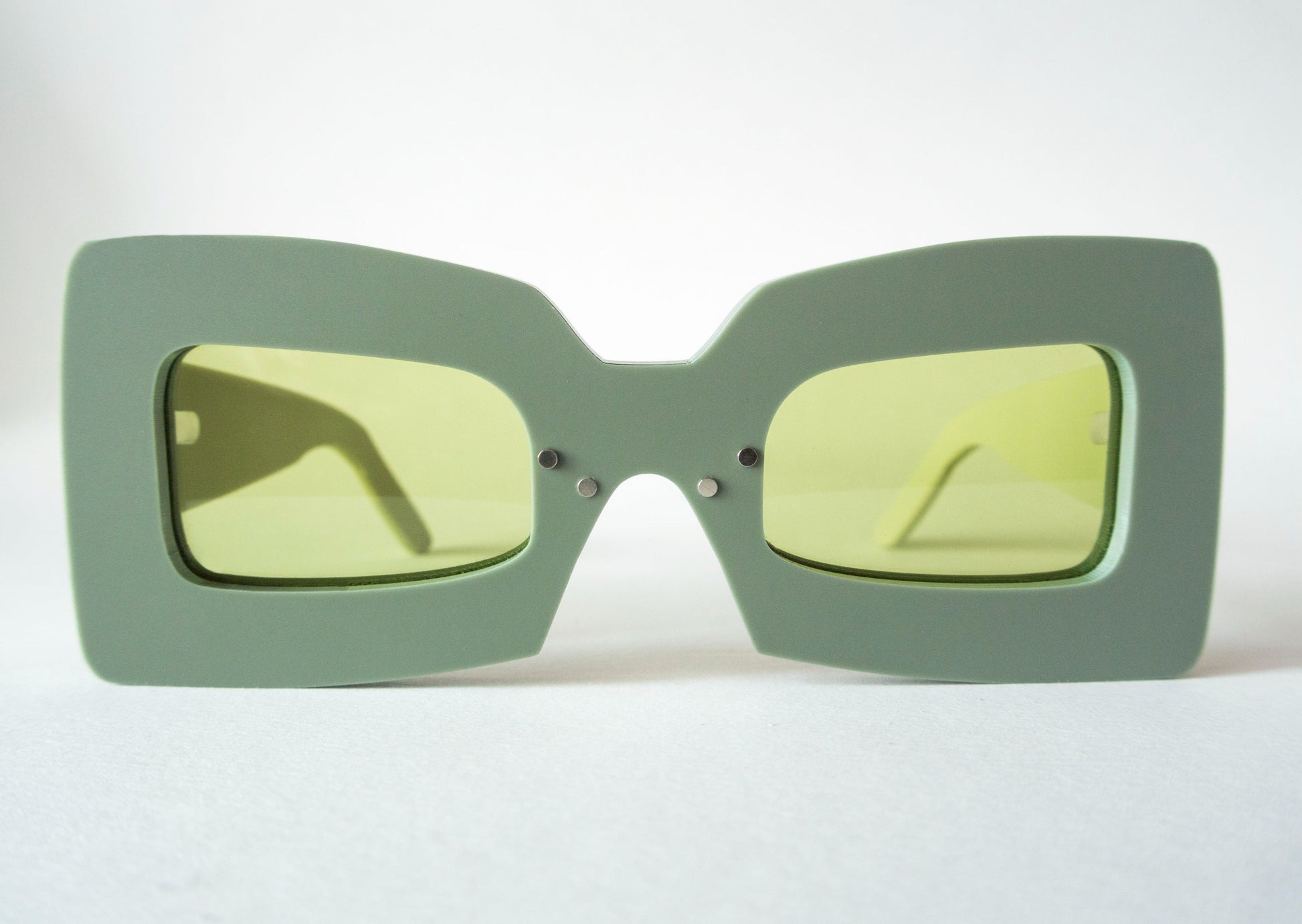 khaki color square shaped glasses with green lenses