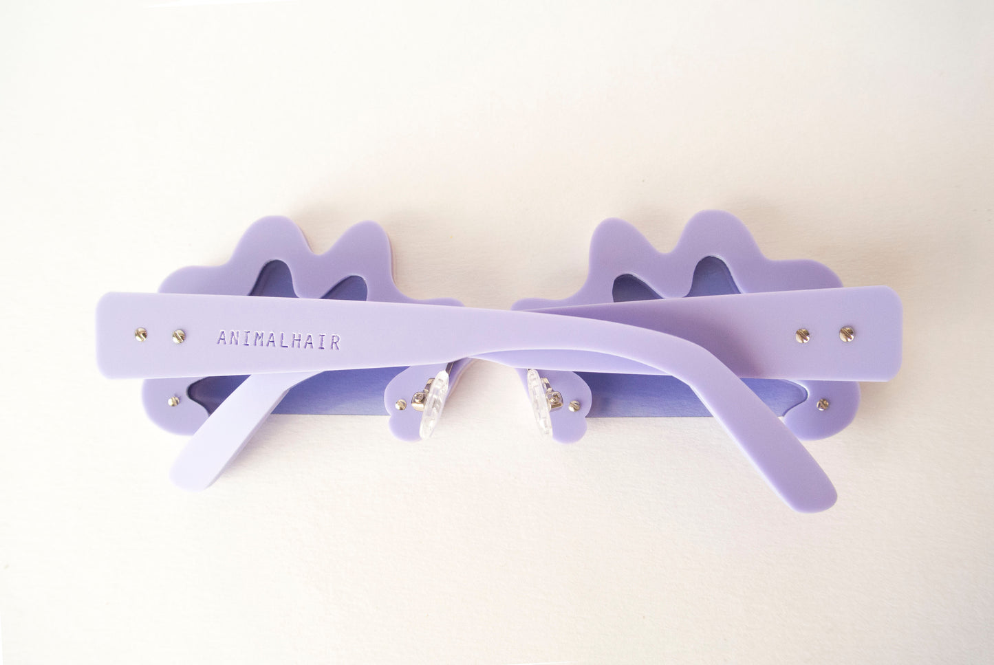 the back view of a pair of lilac sunglasses by anna mulhearn for animalahir eyewear