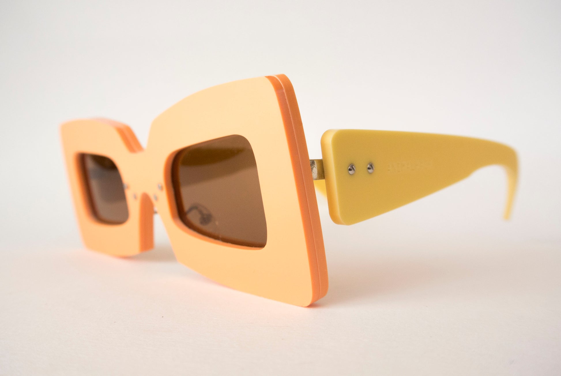 orange square shaped glasses with pale yellow temples