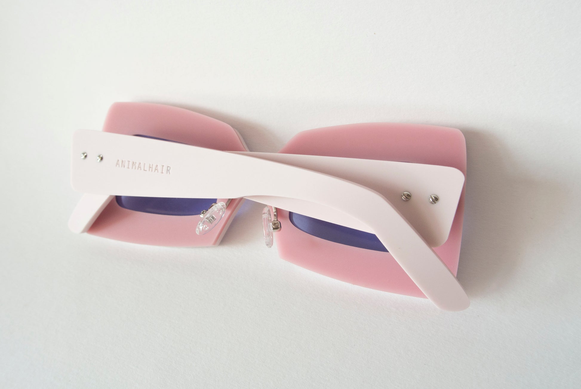 pink sunglasses in a square shape with violet lenses