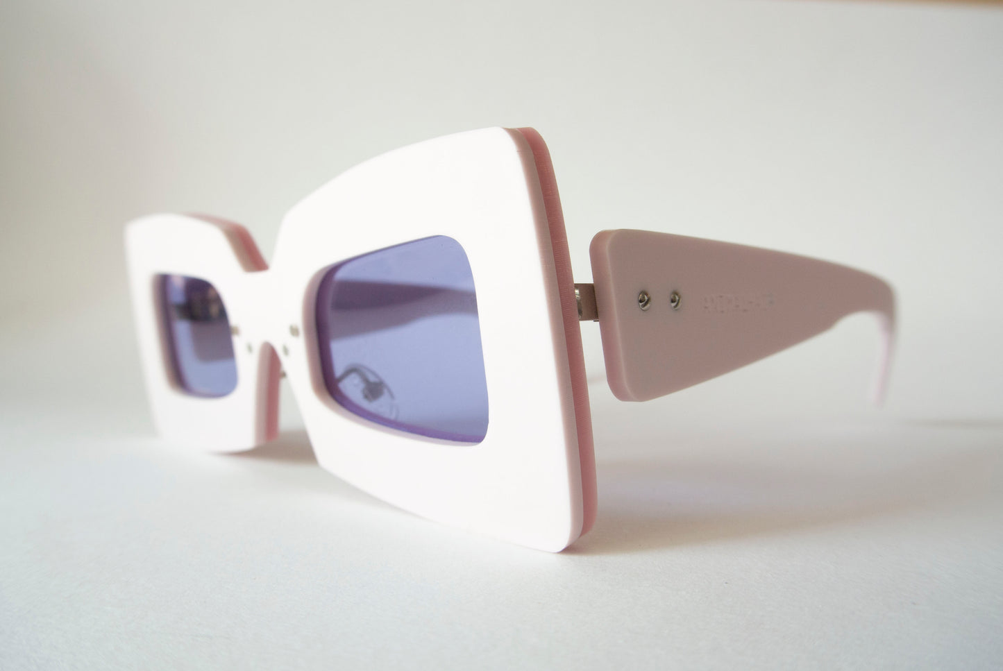 light pink square shaped glasses with violet lenses